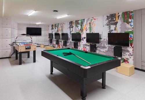 a room with a pool table and several televisions at The GrandResort - Limited Edition by Leonardo Hotels in Limassol