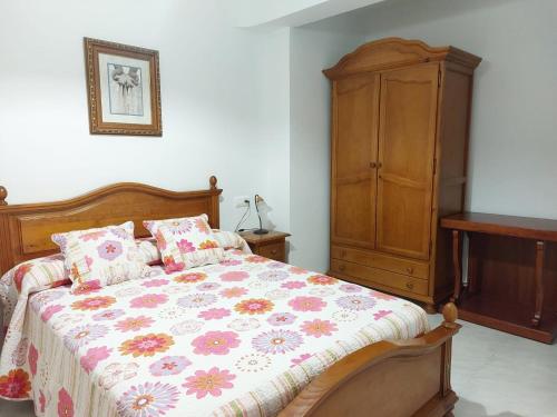a bedroom with a bed and a wooden cabinet at Casa Rural CRISALÉN in Cazorla