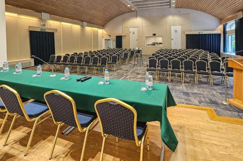 a conference room with a green table and chairs at Dom Pielgrzyma ARKA in Licheń Stary