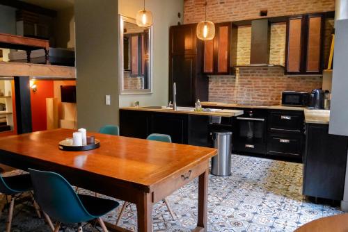 une cuisine avec une table et des chaises en bois dans l'établissement Hiding Place - Loft Toulousain Unique, à Toulouse