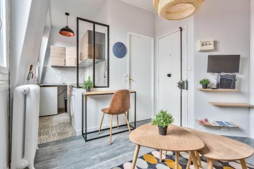 un salon avec une table et deux chaises dans l'établissement Studio Cozy avec vue sur la tour Eiffel, à Clichy
