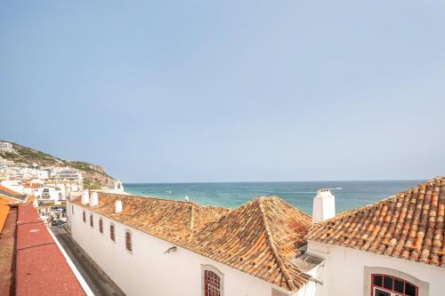 a view of the ocean from the roofs of buildings at GuestReady - Beachfront dream in Sesimbra in Sesimbra