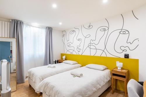 two beds in a room with a mural on the wall at GuestReady - Glamourous getaway in the 20th Arr. in Paris