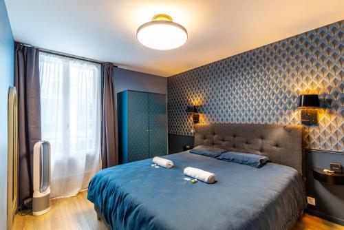 een slaapkamer met een groot bed met 2 kussens erop bij GuestReady - Glamourous getaway in the 20th Arr. in Parijs