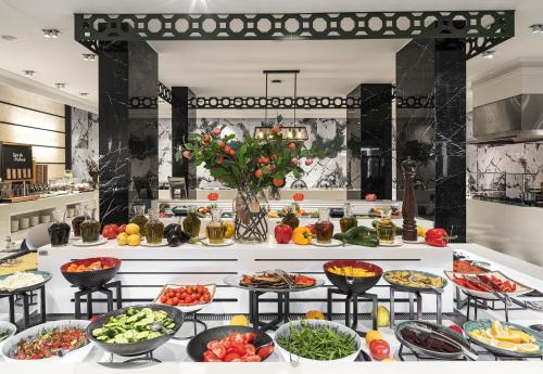 a buffet with many plates of food on a table at The GrandResort - Limited Edition by Leonardo Hotels in Limassol