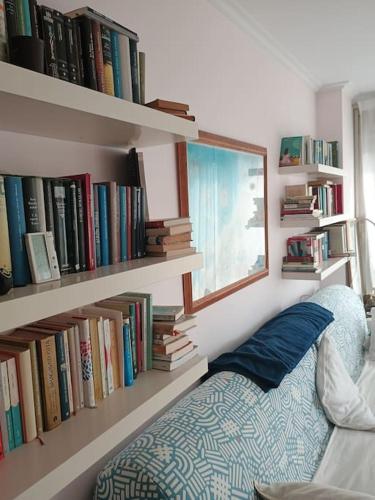 a living room with a book shelf with books at El Camarote de Beiramar in Cedeira