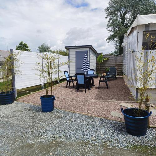 a patio with a table and chairs and a shed at Mobil-home dans camping calme in Pénestin