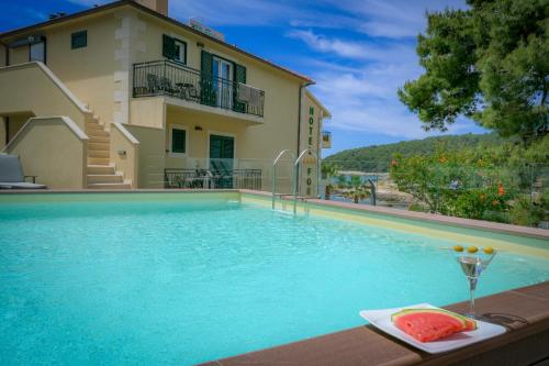 a swimming pool in front of a house at Hotel Fortuna in Hvar