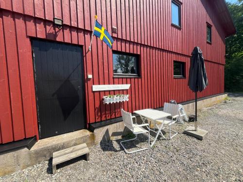a red building with a table and chairs and a flag at Borgane 5 in Fjällbacka