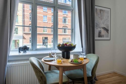 a table with a bowl of fruit on it in front of a window at Perfect Couples Retreat in Urban Area in Copenhagen
