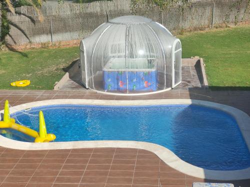 a small pool with a toy house in a igloo at habitaciones en Chalet con piscina y jacuzzi en Madrid in Algete