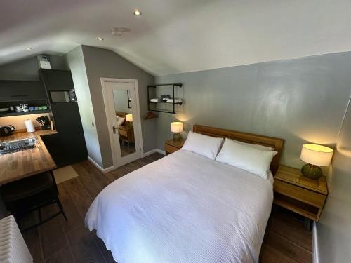 a bedroom with a large white bed with two lamps at Garden Lodge in Belfast