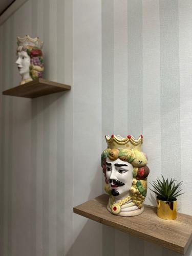 a statue of a woman with a crown on a shelf at Doctor House standard, suites & luxury rooms in Enna