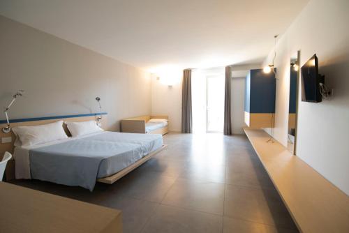 Habitación de hotel con cama y TV en Hotel Bacino Grande, en Torre Lapillo