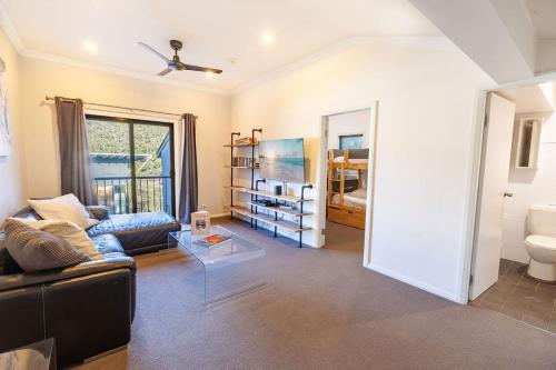 a living room with a couch and a table at Snowcreek 2 Alpine Chalet, Private Garage in Thredbo