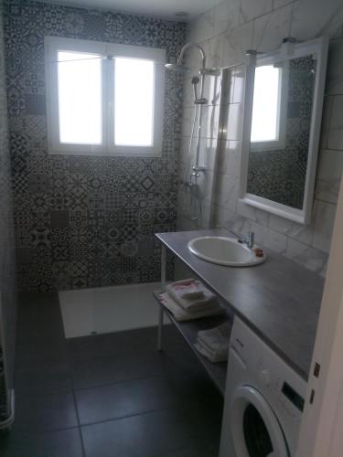 une salle de bain avec un lavabo, une douche et un miroir dans l'établissement maison pour vacances en famille, à Biscarrosse