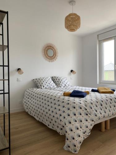 une chambre avec un lit avec une couette et une fenêtre dans l'établissement Les Apparts de St Mart, à Bréhal