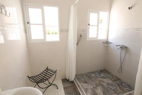 een witte badkamer met een douche en een raam bij TESS Villa Ellen Maria: Space, Activity, Freedom! in Alhaurín de la Torre