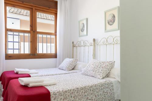 Habitación blanca con 2 camas y toallas. en Apartamento Playa de Regla con terraza 1, en Chipiona