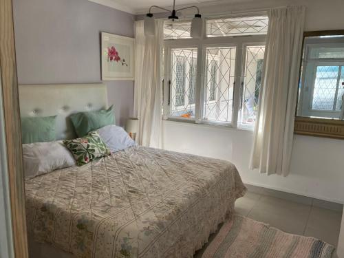 a bedroom with a bed and two windows at Milkwood Haven in Pennington