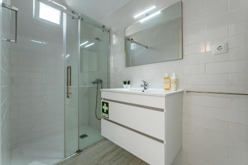 a white bathroom with a sink and a shower at Casa da Quinta in Foz do Sousa
