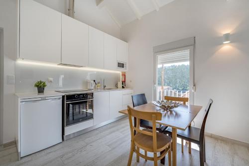 a kitchen and dining room with a table and chairs at Casa da Quinta in Foz do Sousa