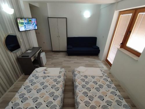 a room with a bed and a desk and a tv at Villa Rimari in Ohrid