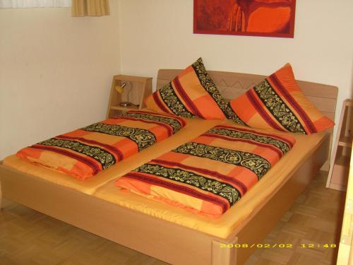 ein Bett mit bunten Decken und Kissen darauf in der Unterkunft Ferienhaus im Golfpark in Haren