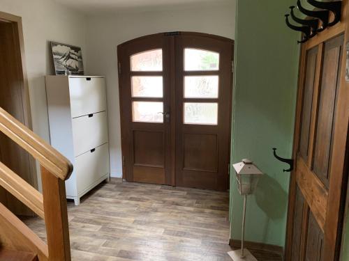 a room with a door and a refrigerator and a staircase at Willma Ferienhaus in Altdöbern
