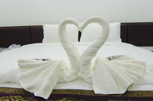 two swansuitsrendered to look like swan towels on a bed at NP Hotel in Buriram