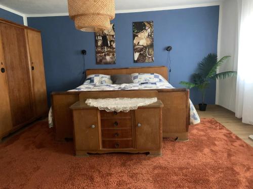 a bedroom with a bed with a nightstand and a table at Willma Ferienhaus in Altdöbern
