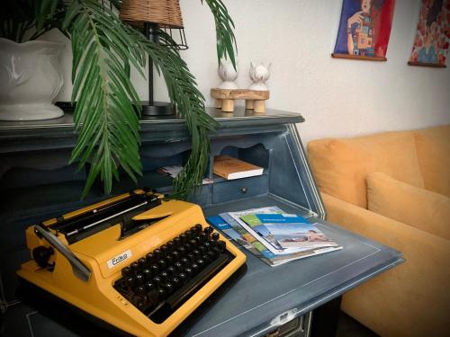 a desk with a yellow typewriter on top of it at Willma Ferienhaus in Altdöbern