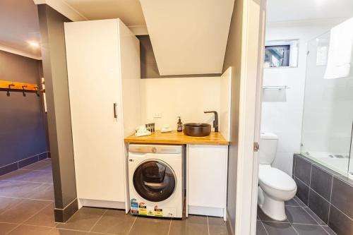a bathroom with a washing machine and a toilet at Snowcreek 2 Alpine Chalet, Private Garage in Thredbo