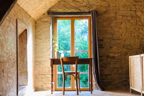 a wooden chair sitting in front of a window at Gîte au Bray in Bellenaves