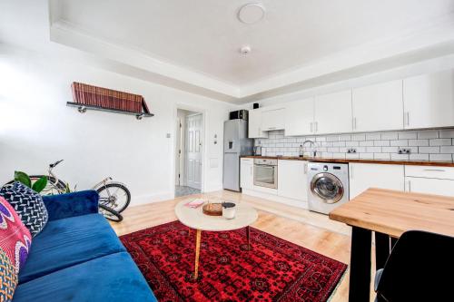 ein Wohnzimmer mit einem blauen Sofa und einem Tisch in der Unterkunft GuestReady - Estadia de charme em Limehouse in London