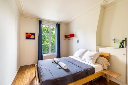 een kleine slaapkamer met een bed en een raam bij GuestReady - Estadia na moda em Saint-Mandé in Saint-Mandé