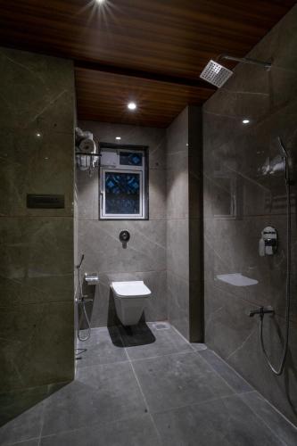 a bathroom with a shower and a toilet and a sink at Hotel Aura Inn Airoli ,Digha in Navi Mumbai