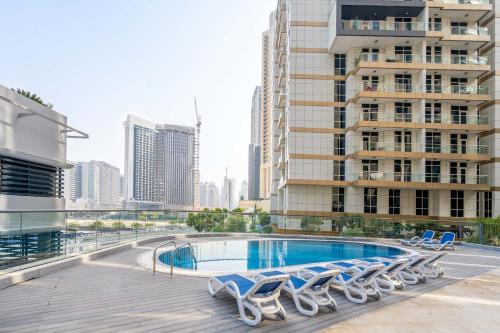 - une piscine sur le toit d'un immeuble avec des chaises longues dans l'établissement GuestReady - Luxe living near Burj Khalifa, à Dubaï