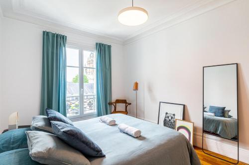 une chambre avec un grand lit et un miroir dans l'établissement GuestReady - Stately Haven near Pantheon, à Paris