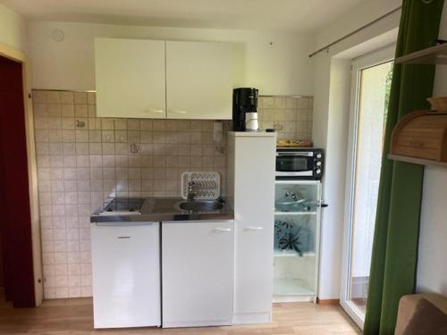 a kitchen with white cabinets and a counter top at Gästehaus Koch in Zöblen