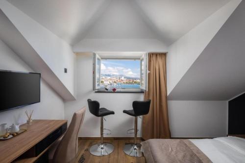 a bedroom with a bed and two chairs and a window at Top rooms in Split
