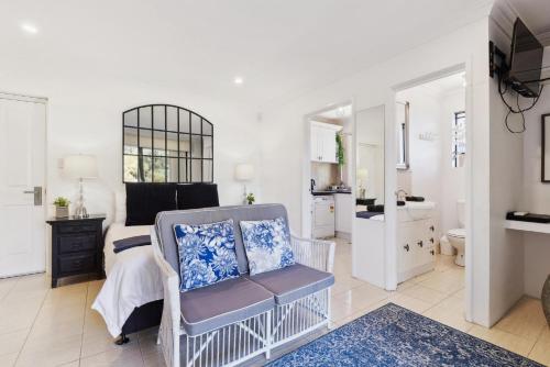 a bedroom with a bed and a chair and a bathroom at WOOD14 - River Suite in Perth