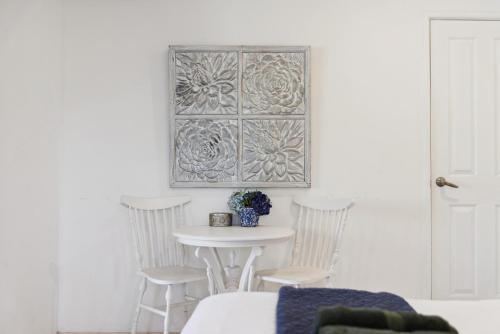 柏斯的住宿－WOOD14 - River Suite，白色的房间里一张桌子和椅子,墙上挂着一张照片