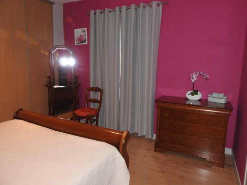- une chambre avec un lit, une commode et un miroir dans l'établissement Domaine des Gardette, à Vaux-en-Beaujolais