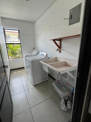 a white bathroom with a sink and a toilet at Maria´s Apartments in Alajuela City