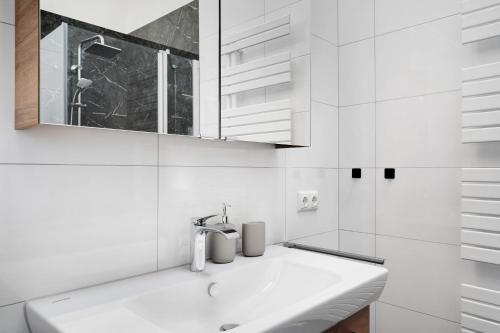 a white bathroom with a sink and a mirror at Schwarzwaldglück in Oberkirch