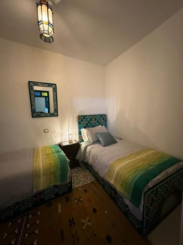 a bedroom with two beds and a mirror at Dar Al Mansoura RIAD in Chefchaouene