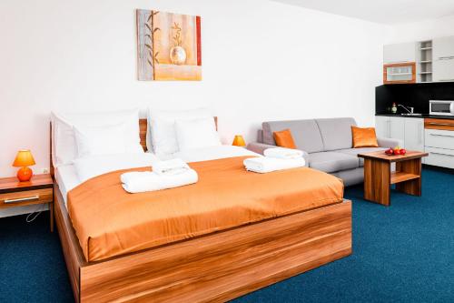 a bedroom with a large bed and a couch at Apartmanovy dom Familia Smokovec in Vysoke Tatry - Stary Smokovec