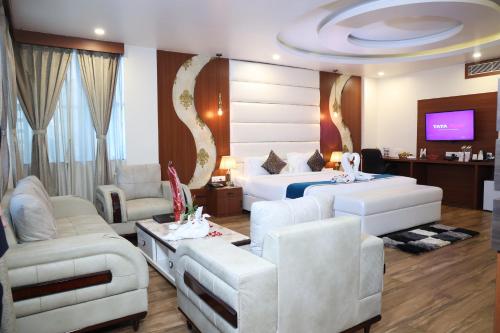 Hotel Sidh Vedantha في باتنا: غرفة فندقية بسريرين وتلفزيون