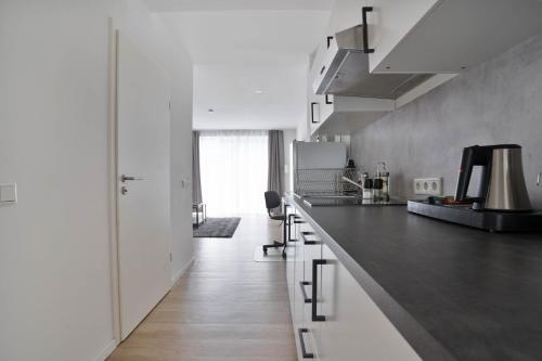 a kitchen with white cabinets and a black counter top at Apartments in the city center I private parking I home2share in Dortmund